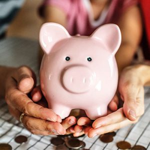 Two hands holding a piggy bank of personal savings 