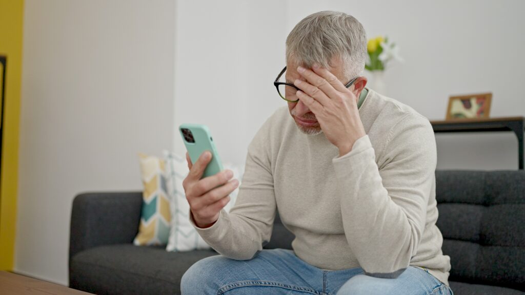 An elderly man looking at a deepfake on this phone