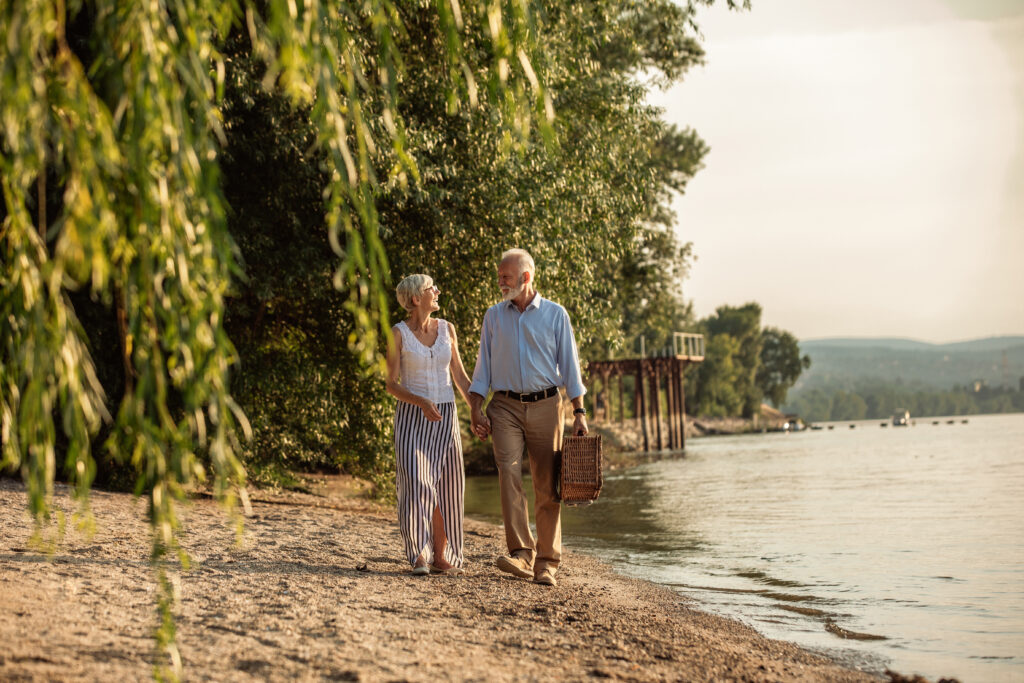 Lovely summer day elderly walking on a beach during a Lovely summer day after getting Financial Advice for Retirement