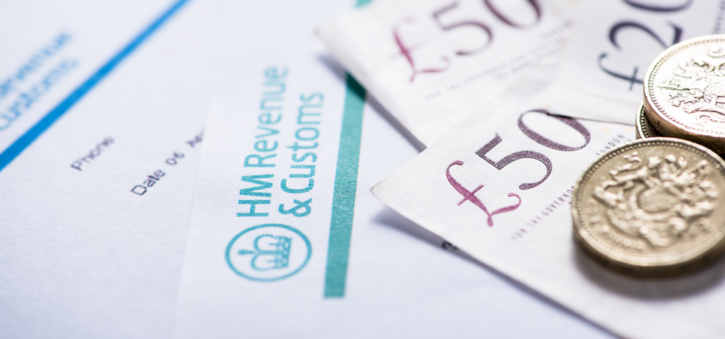 Some papers, bank notes, and pound coins. The papers have 'HM Revenue & Customs' visibly printed on them.